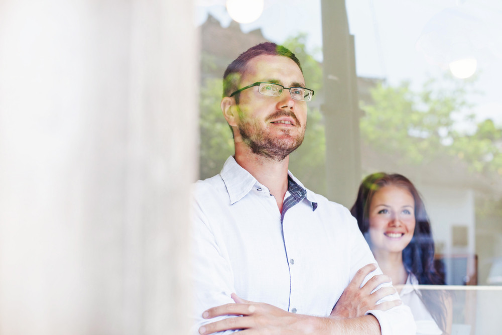 Couple looking out their new window (6 Compelling Reasons Why You Should Replace Your Old Windows)